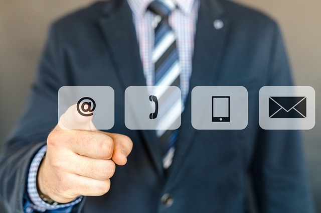 A person in a suit points at icons representing email, phone, mobile device, and mail, highlighting various communication methods. This scene underscores the power of Email Marketing Solutions in driving subscriber growth through effective automation tools.